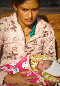 Frau beschützt Neugeborenes in Kathmandu